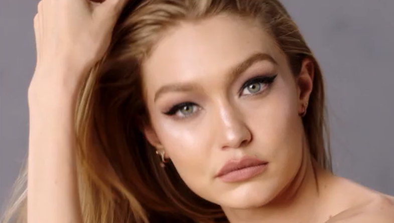 Gigi Hadid posing in a runway outfit at a fashion event